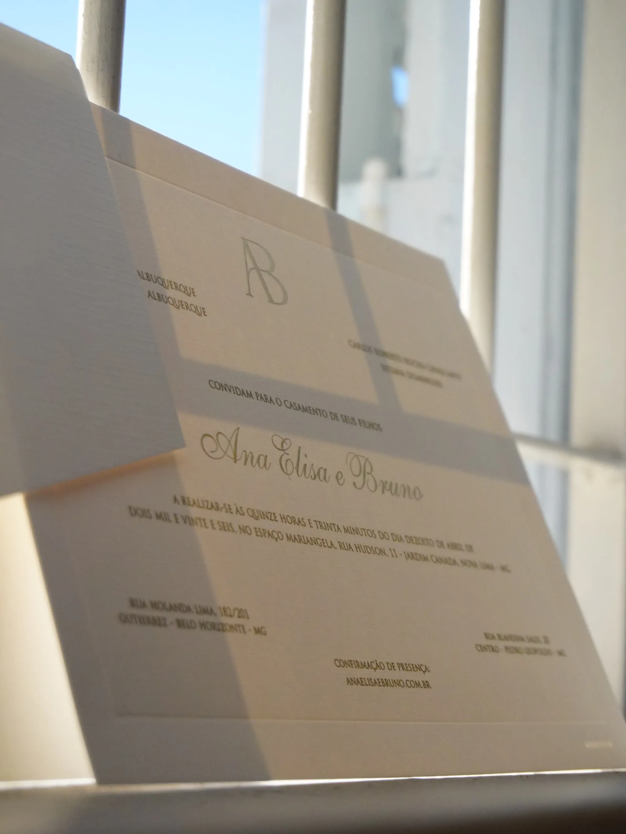 Detalhe de relevo seco e hot stamping em monograma de convite de casamento artesanal